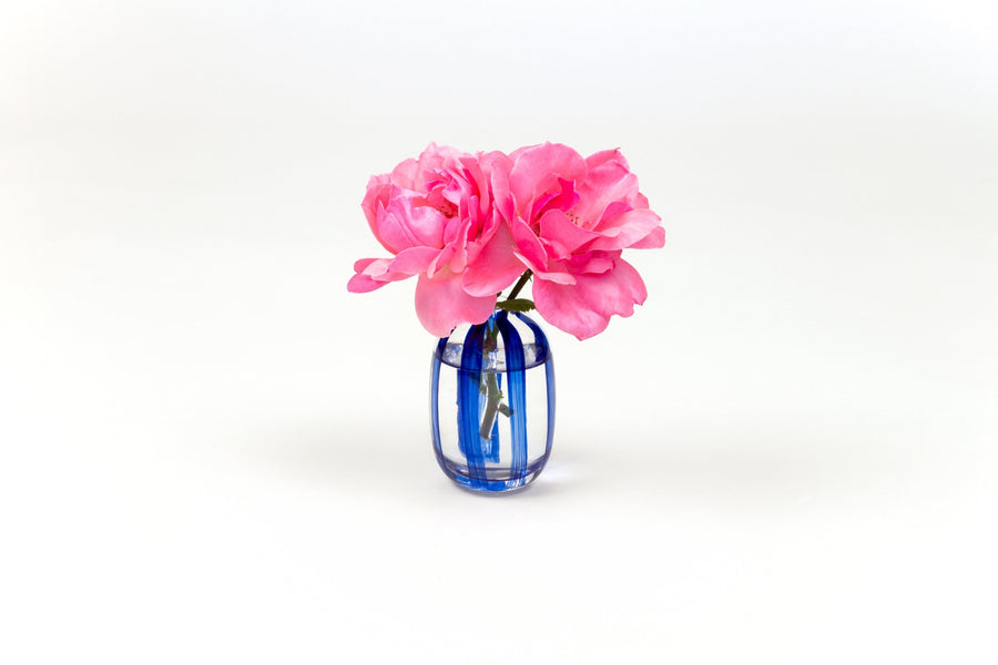 Hand-painted striped glass bud vase in lapis blue with two pink garden roses