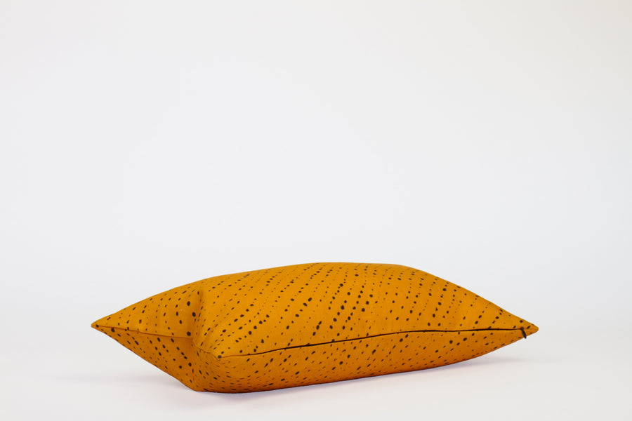 Side view 12” x 20” 100% linen staccato nero shibori pillow in marigold yellow with hidden zipper