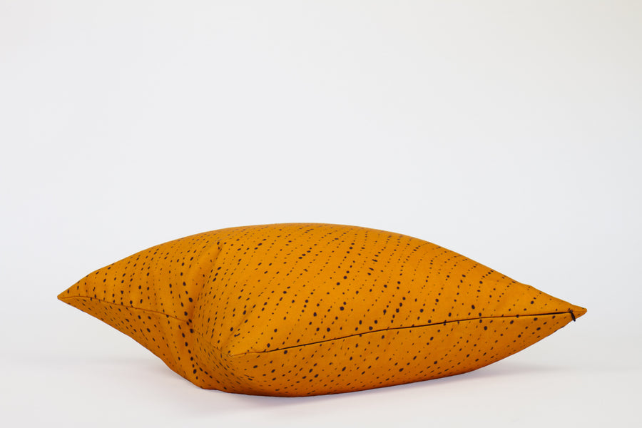 Side view 20” x 20” 100% linen staccato nero shibori pillow in marigold yellow with hidden zipper