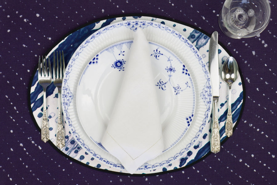Place setting with 100% linen glissando shibori marine blue placemat on sapphire linen with blue & white plates