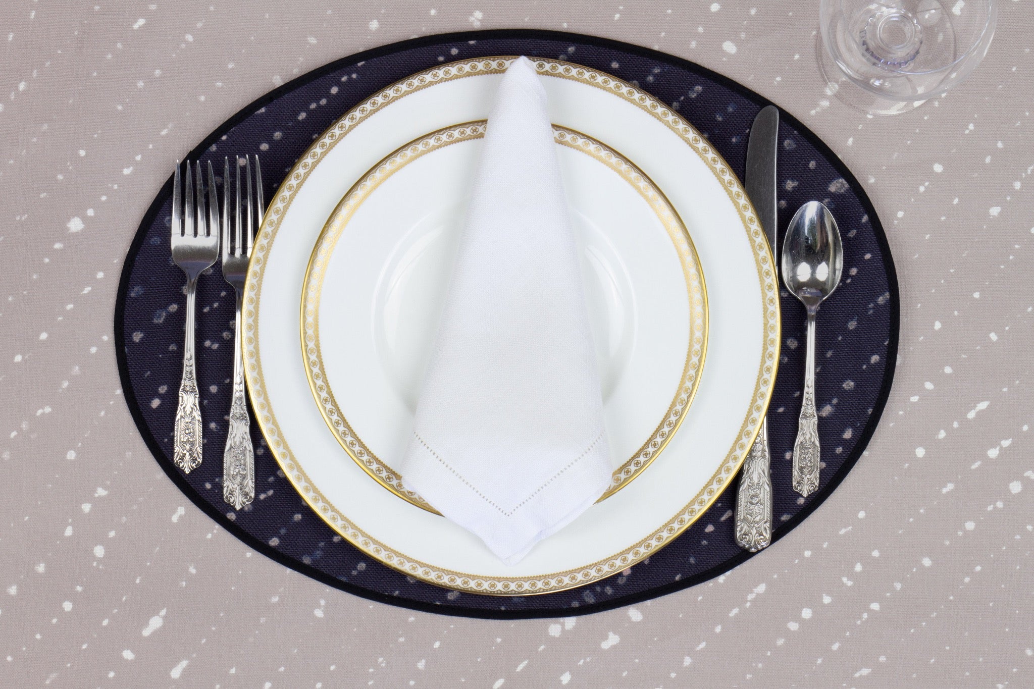 Place setting with 100% linen staccato decolorato shibori midnight blue placemat on flax shibori linen with white plates