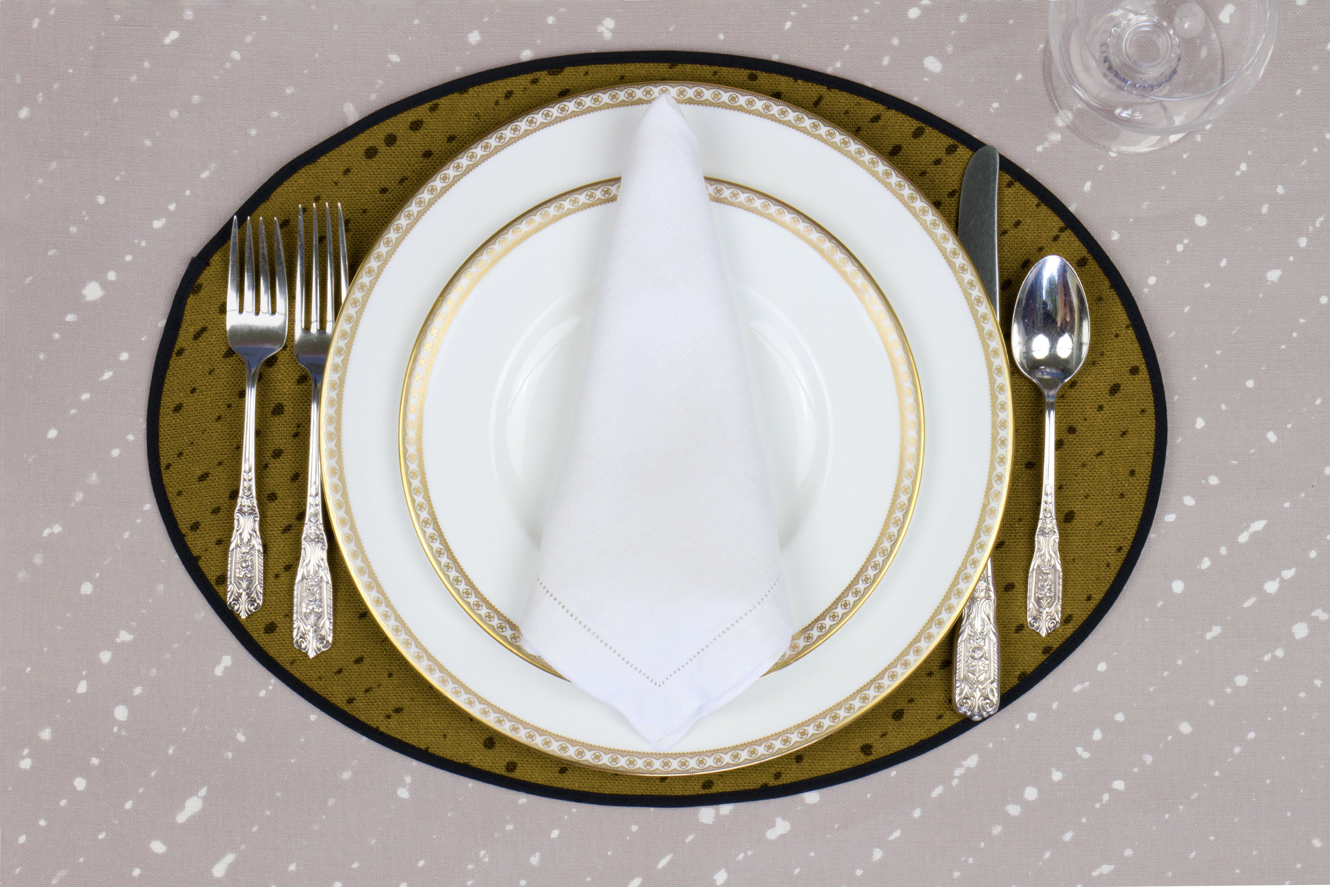 Place setting with 100% linen staccato nero shibori moss green placemat on flax shibori linen with white plates