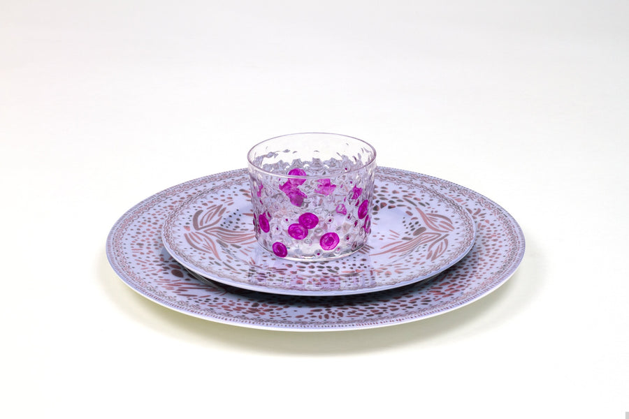 Place setting of hand-painted magenta glass stacked on myrtle mosaic garden salad and dinner porcelain plates