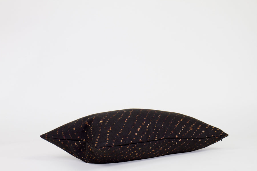 Side view 12” x 20” 100% linen staccato decolorato shibori pillow in onyx black with hidden zipper