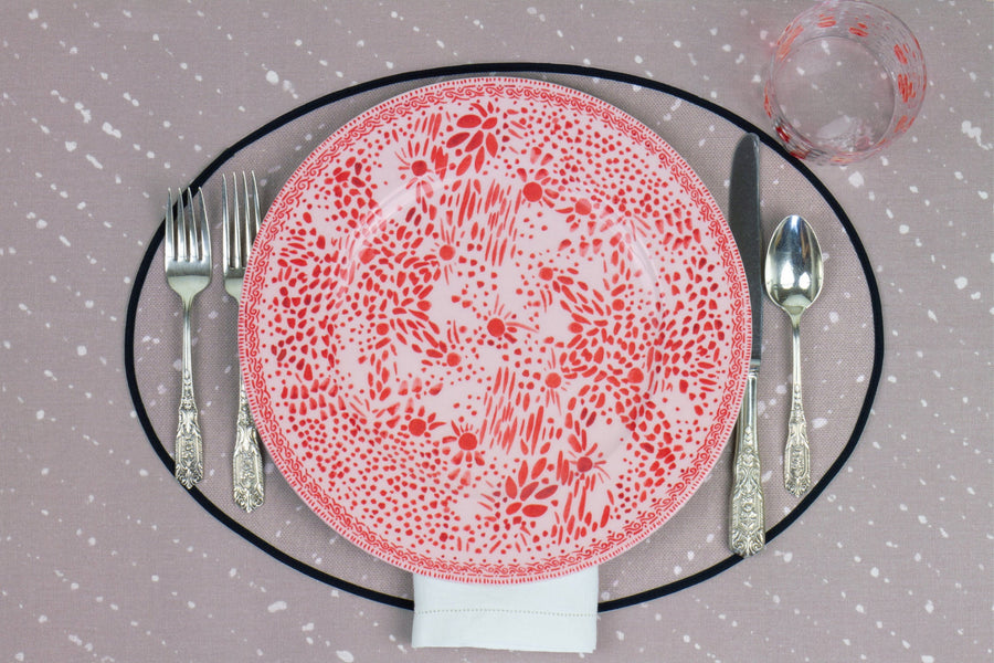Venable Moore Mosaic Garden dinner plate in pale orchid pink with hand-painted Bubble glass on neutral flax tan 'Staccato Sbiancato' Shibori linen placemat and tablecloth with silverware and white linen napkin