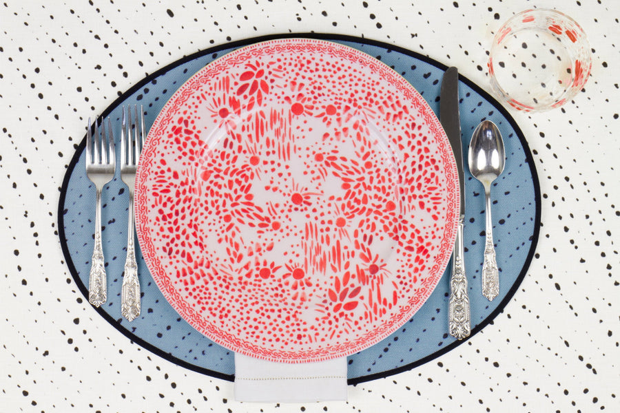 Venable Moore Mosaic Garden dinner plate in pale orchid pink with hand-painted Bubble glass on sky blue 'Staccato Neroo' Shibori linen placemat and alabaster white tablecloth with silverware and white linen napkin