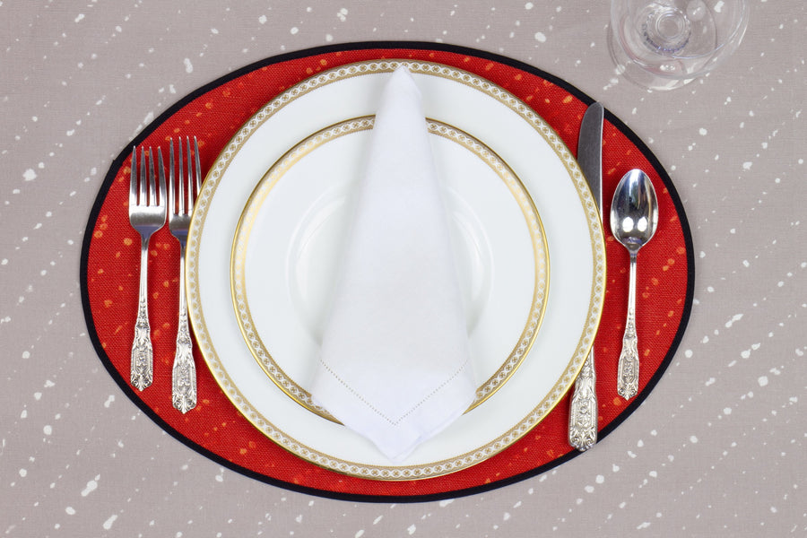 Place setting with 100% linen staccato decolorato shibori paprika red placemat on flax shibori linen with white plates