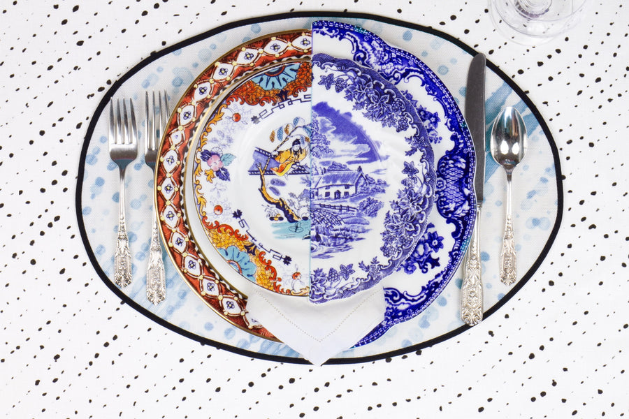 Place setting with 100% linen glissando shibori powder blue placemat on alabaster shibori linen with colored plates