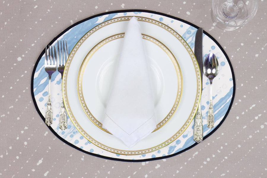 Place setting with 100% linen glissando shibori powder blue placemat on flax shibori linen with white plates