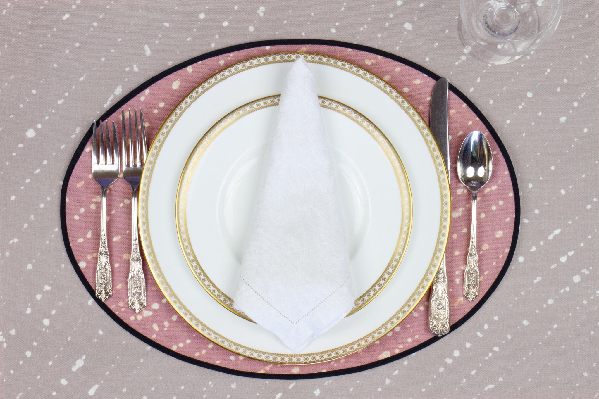 Place setting with 100% linen staccato decolorato shibori rose clay pink placemat on flax shibori linen with white plates