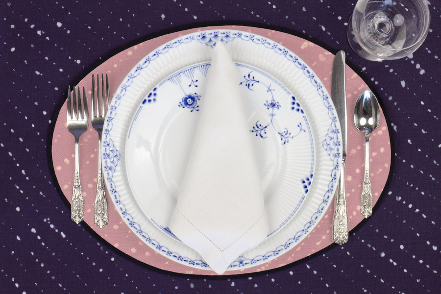 Place setting with 100% linen staccato decolorato shibori rose clay pink placemat on linen with blue & white plates