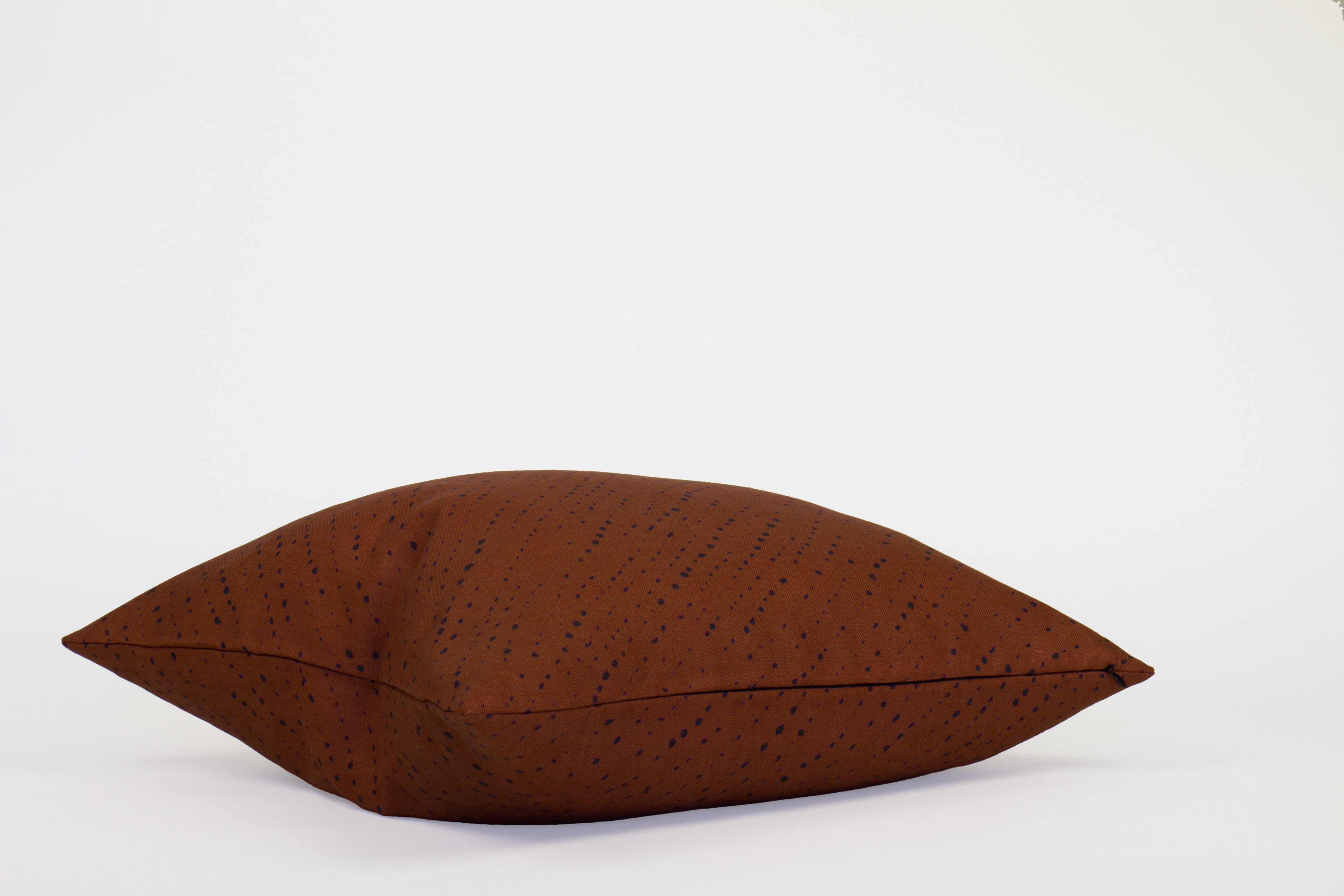 Side view 20” x 20” 100% linen staccato nero shibori pillow in russet brown with hidden zipper