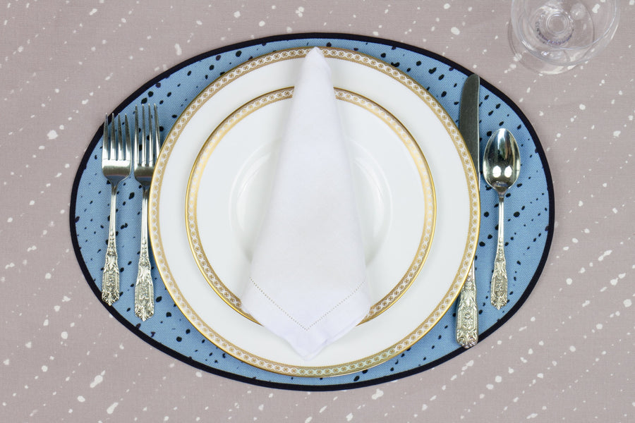Place setting with 100% linen staccato nero shibori sky blue placemat on flax shibori linen with white plates