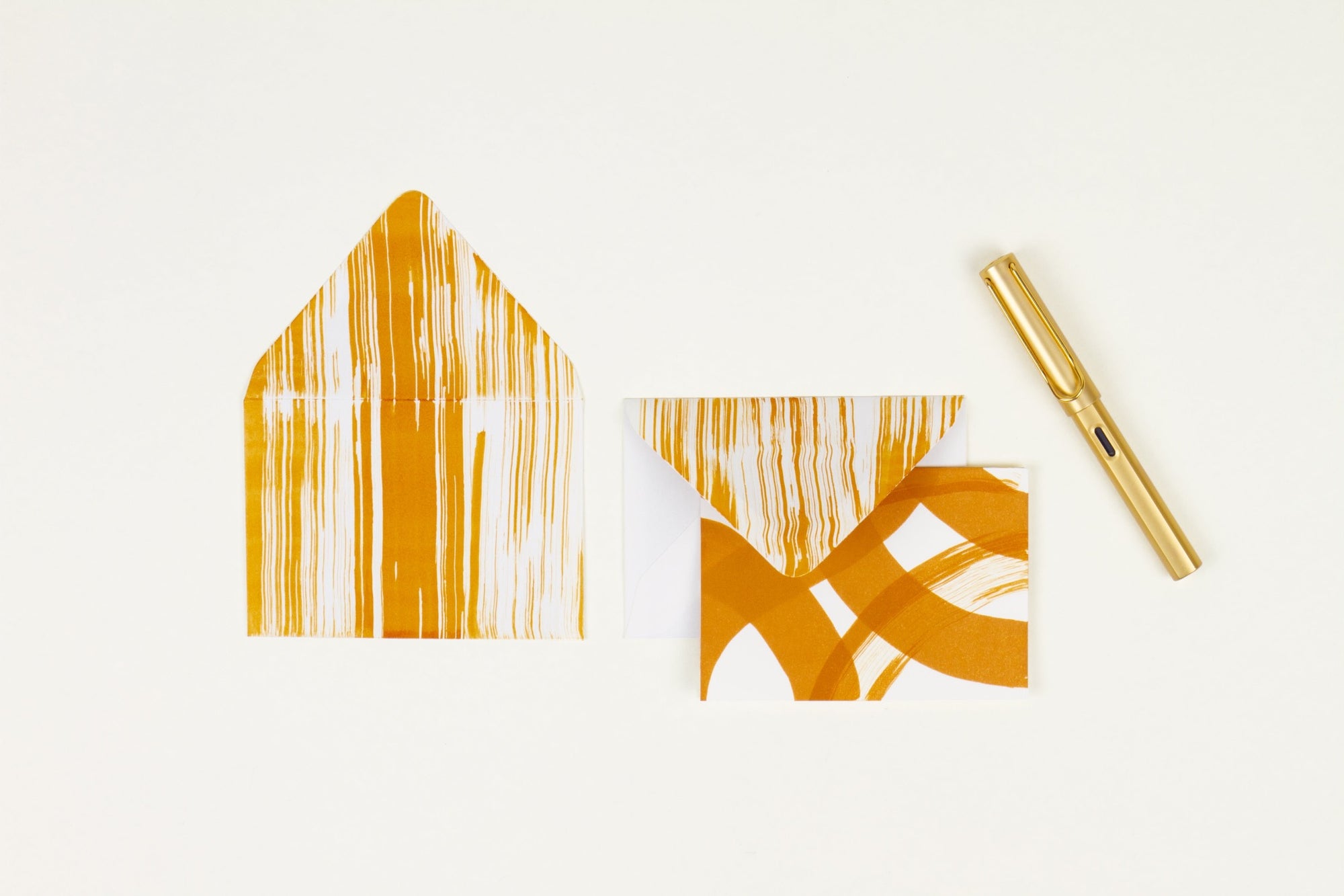 Hand-painted card and crimson lined envelopes in ochre in ‘stripes and squiggles’ pattern with gold pen