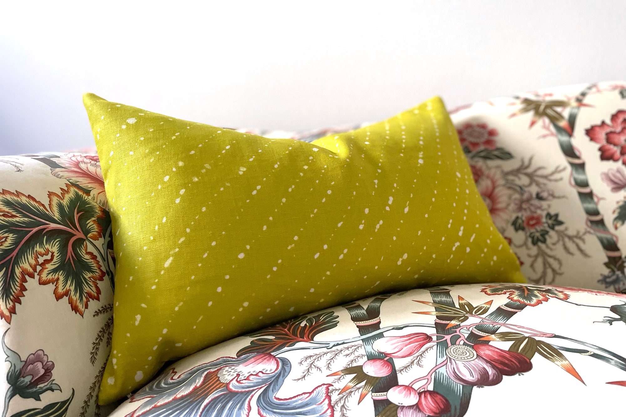 pear green 'staccato sbiancato' shibori pillow in fine linen fabric by the yard on a patterned sofa